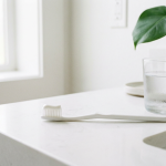 White toothbrush with peroxide-free whitening toothpaste beside a glass of water